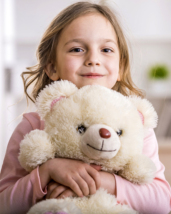 Girl cuddling a teddy bear asknig for donations