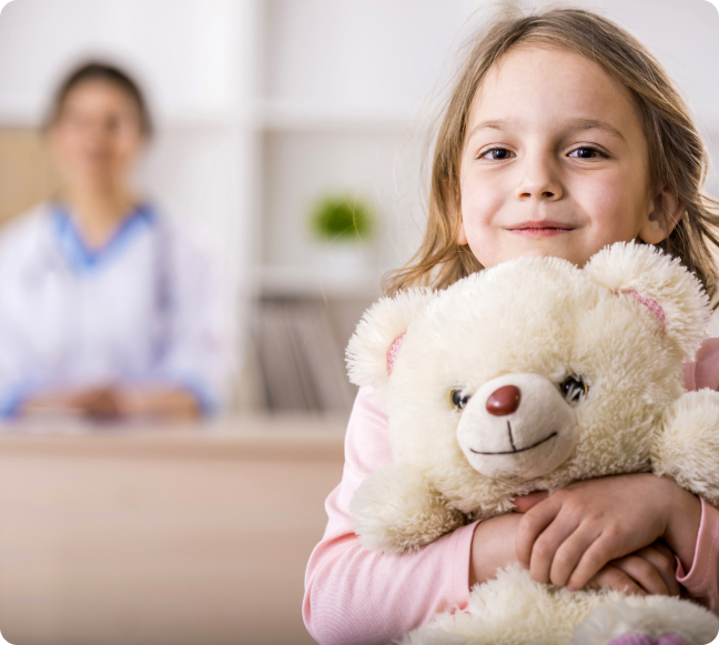 Girl in a hospital holding a Teddy Bear