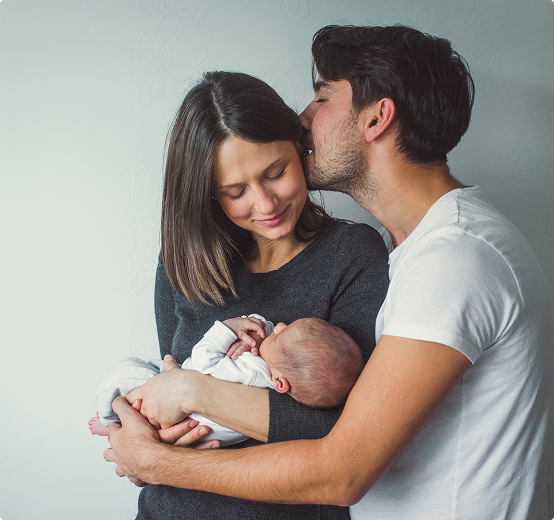 A mother and father holding their newborn baby